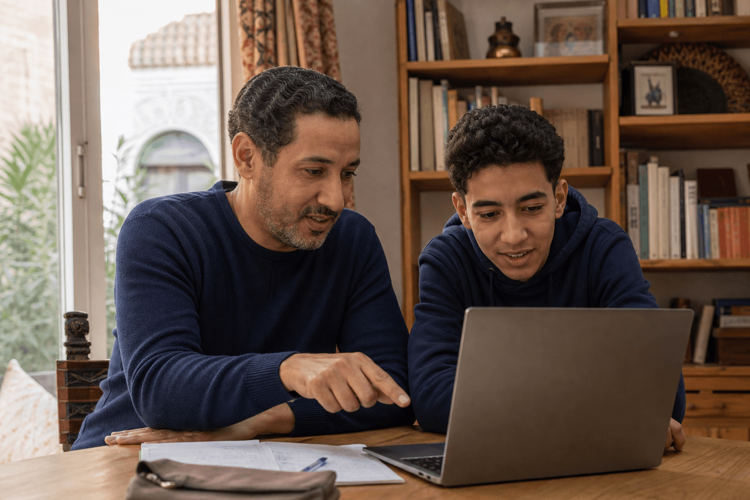 Un père consulte la progression scolaire de son fils